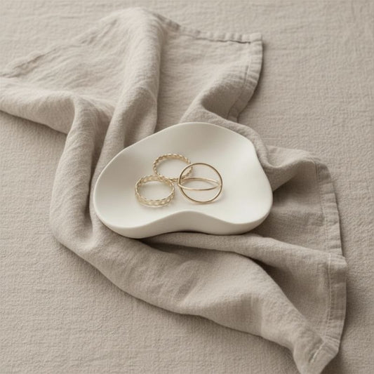 Wave tray with natural finish with gold jewellery on beige fabric