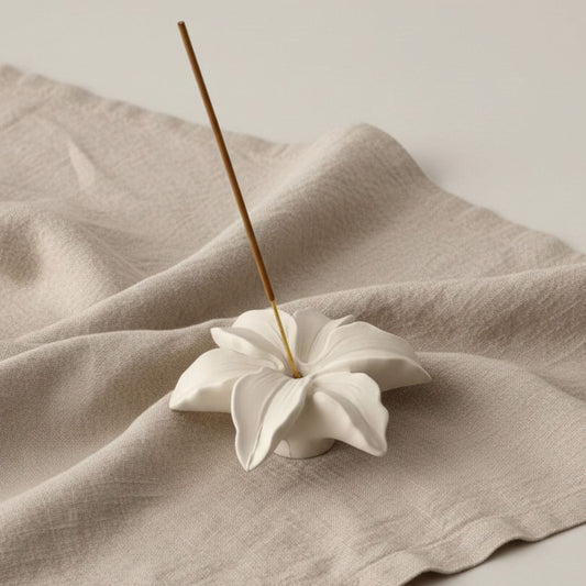Lily Incense Holder with natural finish on a beige fabric background