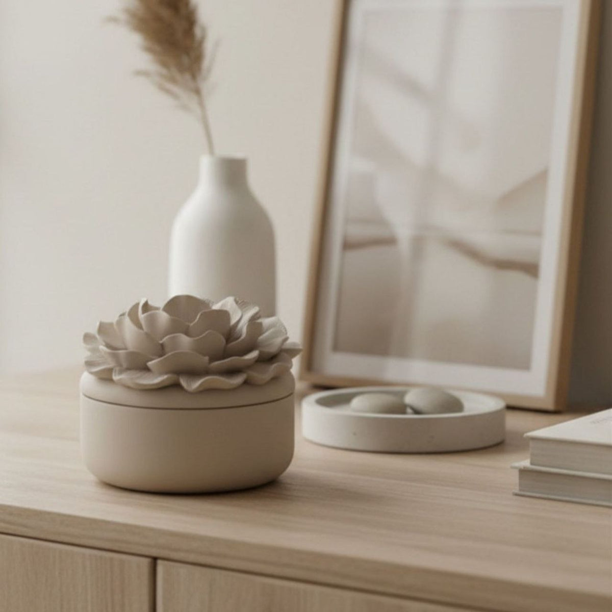 Camelia jar and lid with a taupe finish on a dresser with neutral decor