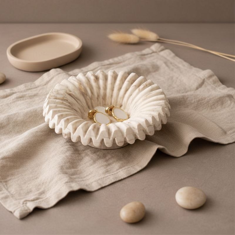 Ripple tray with marble finish with gold jewellery on a beige fabric and ceramic tray