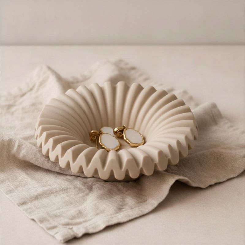 Ripple tray with taupe finish with gold ear rings on fabric