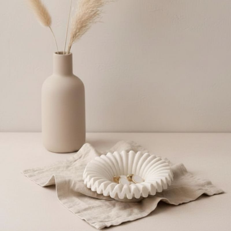 Ripple tray with natural finish with gold ear rings on fabric and a ceramic vase