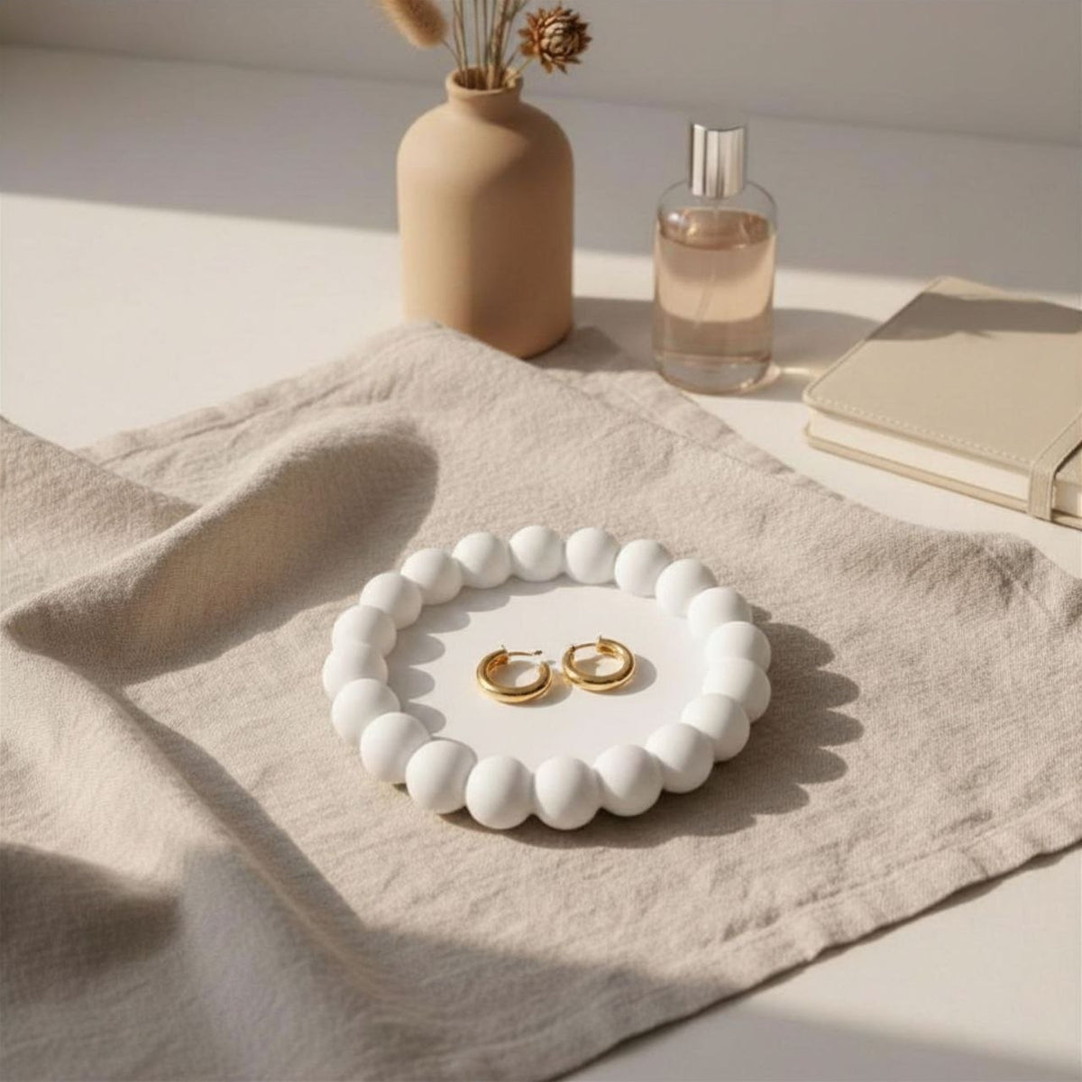 Natural colour bubble tray with jewellery, a vase, a book and perfume