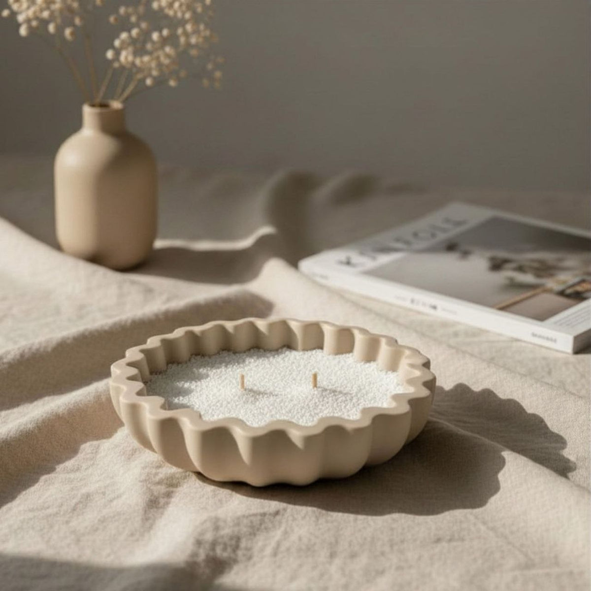 Fluted bowl with a taupe finish on a fabric surface with neutral decor in the background