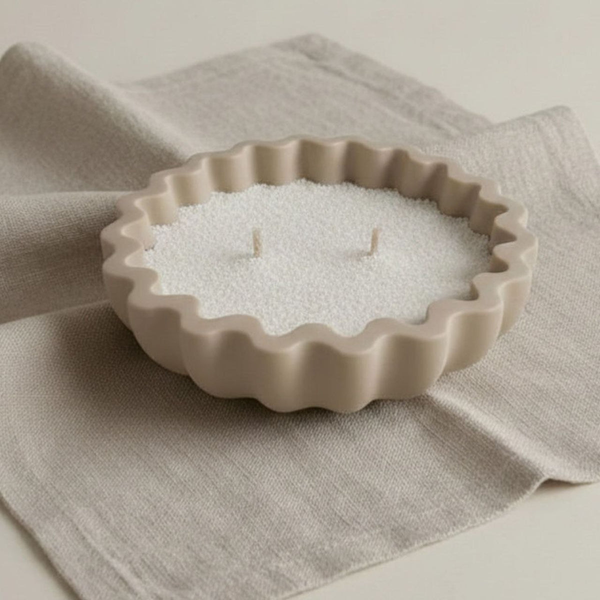 Fluted bowl with a taupe finish with wax sand on a beige background