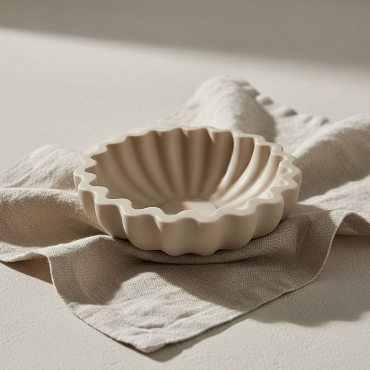 Fluted bowl with a taupe finish on a beige background