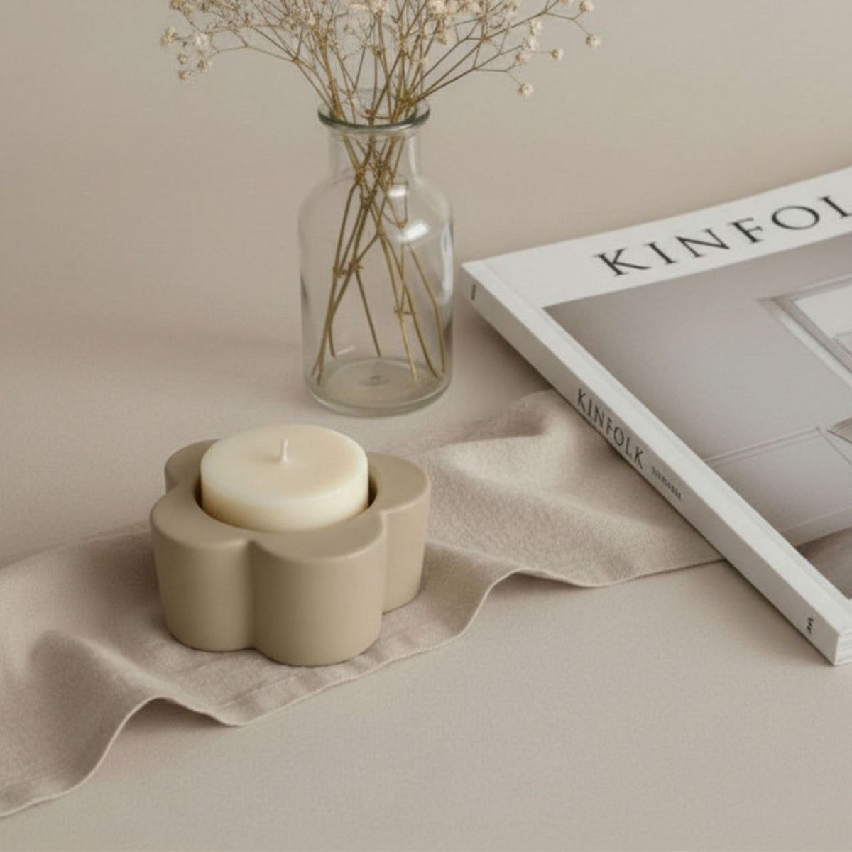 Daisy Candle holder in taupe finish  on a beige background with neural decor