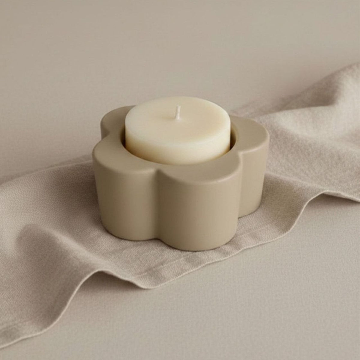 Daisy Candle holder in taupe finish with a candle