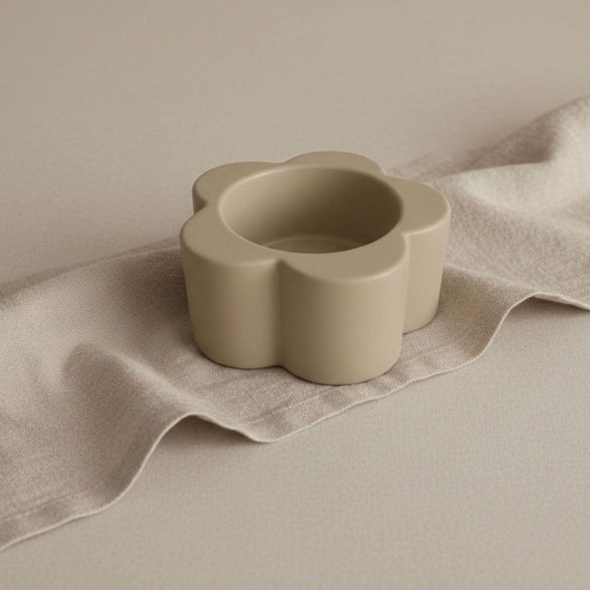 Daisy Candle holder in taupe finish on a beige background