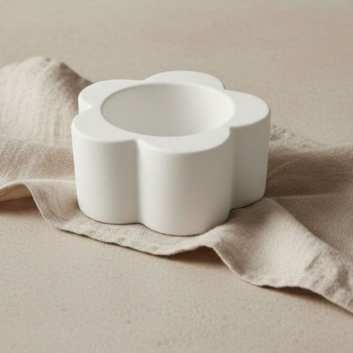 Daisy Candle holder in natural finish on beige fabric