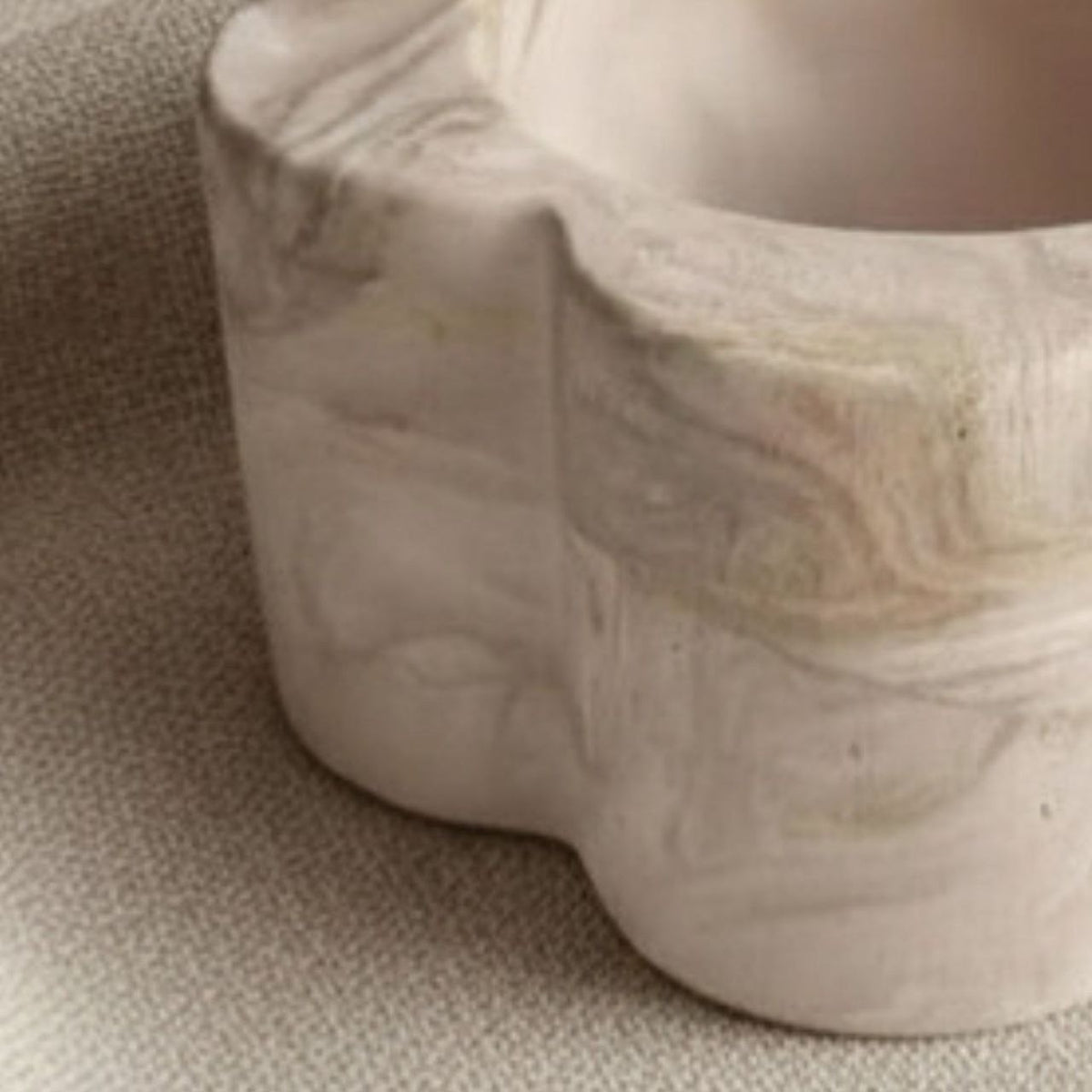 Close-up of  beige marble daisy candle holder