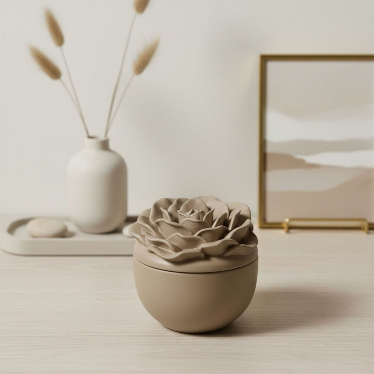 Rose jar and lid in a taupe finish with a ceramic vase and a framed print