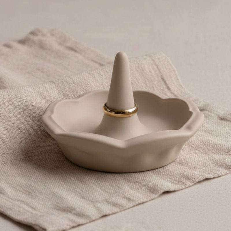 Ring holder in a taupe finish on a fabric background