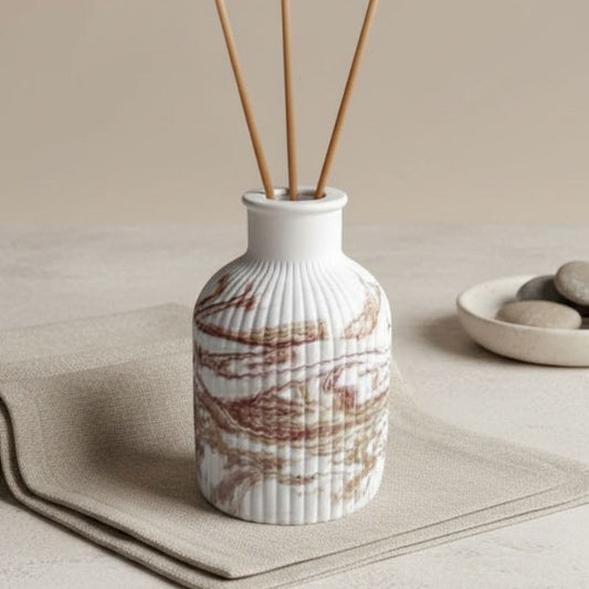 Reed diffuser with a marble finish on a fabric background