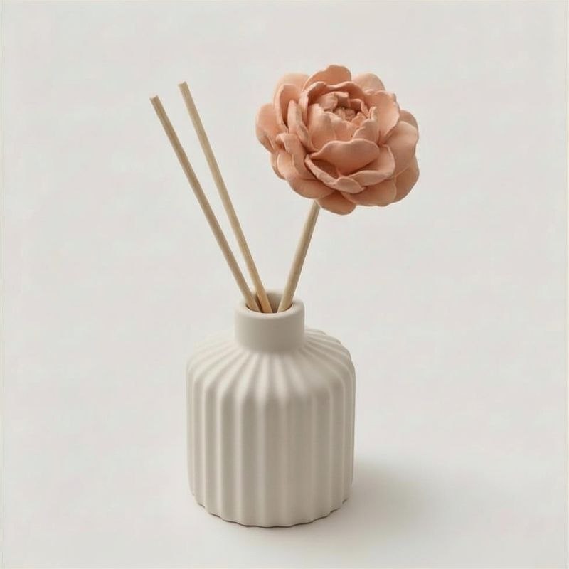 A light terracotta peony diffuser stick n a ceramic diffuser with reeds