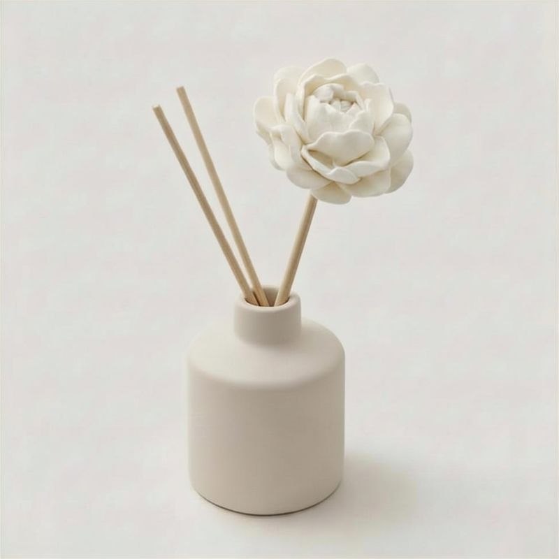 A ceramic diffuser with a natural peony diffuser flower and diffuser reeds